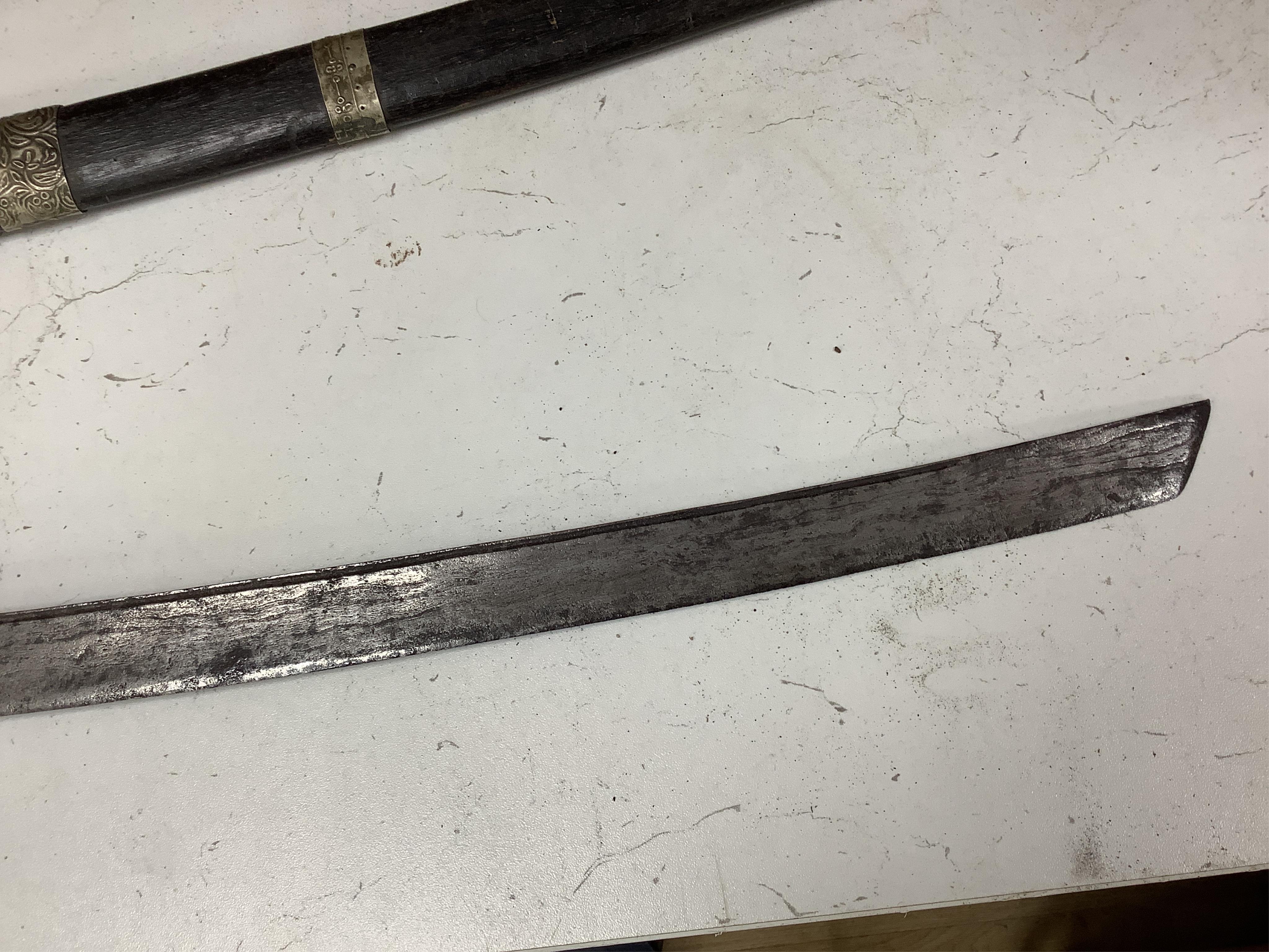 Four bladed weapons; an Indian sword Tulwar, blade 68.5cm. Condition - poor, heavily pitted., A Nepalese Kukri. Condition - fair., A Thai sword Dha, with a lacquered hilt and wooden scabbard, blade 56cm. Condition - fair